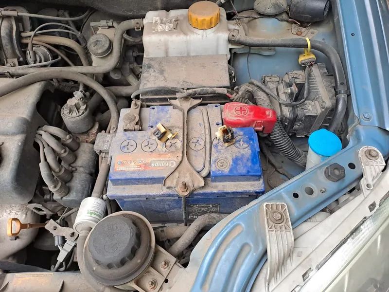 Baterie auto în compartimentul motor